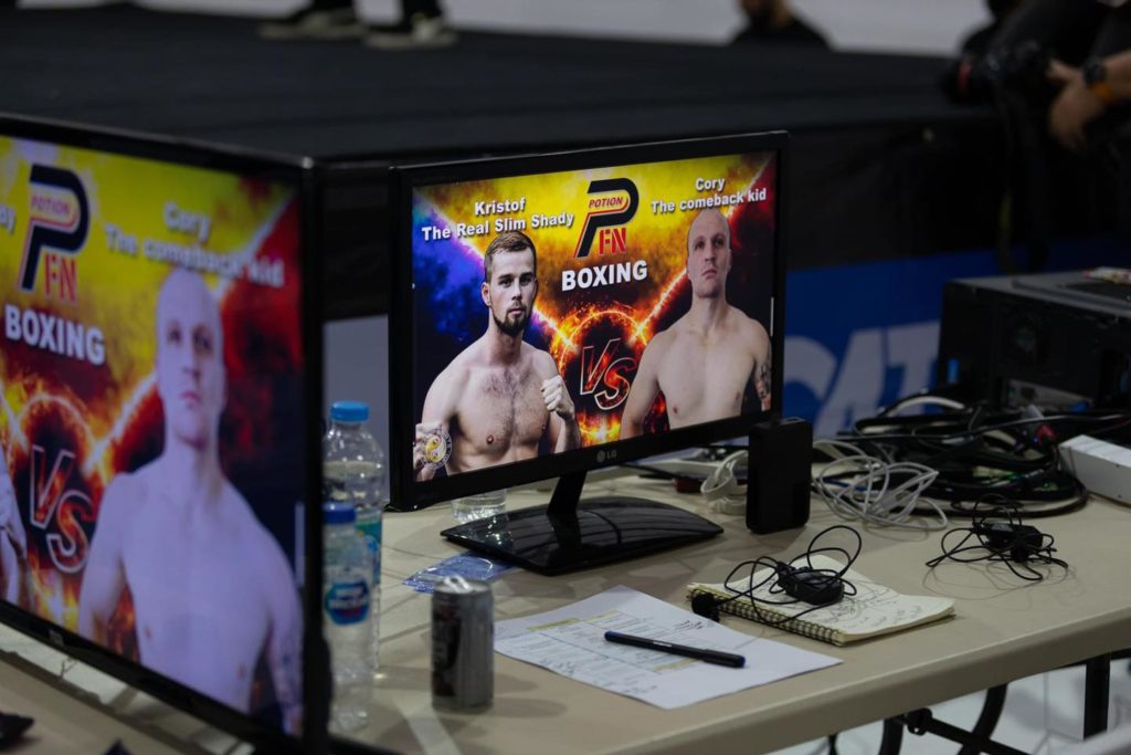 screens on broadcasting table showing the upcoming fight at Potion fight night
